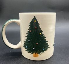 a coffee mug with a christmas tree painted on it