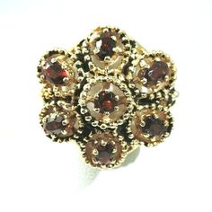 This exquisite vintage ring is crafted from 14K yellow gold and features a large cluster of oval garnets. The ring is size 6 and sizable, it weighs 11 grams. The setting style is a beautiful cluster, making this ring a unique addition to any fine jewelry collection. The main gemstones shape is oval, and the ring is an original piece, not a reproduction. The ring falls under the categories of Rings, Vintage & Antique Jewelry, and Jewelry & Watches. 14K .585 YELLOW GOLD VINTAGE  1 CARAT GARNET FLO Antique Oval Flower Ring For Formal Occasions, Heirloom Oval Flower Ring Hallmarked, Oval Multi-stone Flower Ring For Anniversary, Oval Hallmarked Flower Ring In Fine Jewelry Style, Classic Oval Hallmarked Flower Ring, Heirloom Style Oval Gemstone Flower Ring, Classic Oval Flower Ring, Heirloom Flower Ring With Oval Gemstone, Heirloom Oval Gemstone Flower Ring