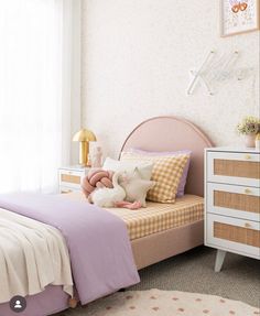 a child's bedroom with pink and white bedding, checkered pillowcases