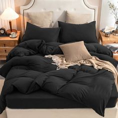 a bed with black comforter and pillows on it