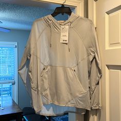 a white shirt hanging on a hanger in front of a door with a window behind it