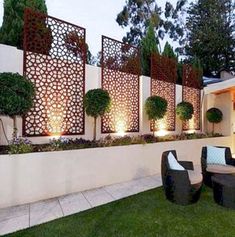 an outdoor seating area is lit up at night with lights shining on the walls and trees