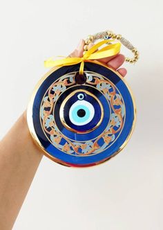 ⭐️Diameter of the blue evil eye bead is 14 cm(5.5 in) ⭐️Height of the blue eye wall charm is 28 cm(11 in) ⭐️Evil eye hanging is gold plated. There are two blue glass beads on the hanging. ⭐️Evil eye bead is painted. ⭐️ Evil Eye is totally handmade. ⭐️The evil eye bead is large and it is perfect for home decoration. ⭐️Turkish eye decor is also gold plated. It is believed that evil eye charm protects you from the evil eyes. Evil eye charm is over 5000 years old. It is found in all major religions Bohemian Blue Evil Eye Bracelet For Festival, Traditional Blue Evil Eye Jewelry, Handmade Blue Evil Eye Bracelet For Festival, Blue Evil Eye Bracelet With Round Beads For Festivals, Blue Evil Eye Bracelet For Festivals, Handmade Blue Evil Eye Bracelet For Good Luck, Evil Eye Hanging, Nazar Amulet, Wall Charm