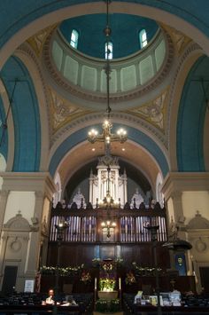 the inside of a church with pews and chandeliers