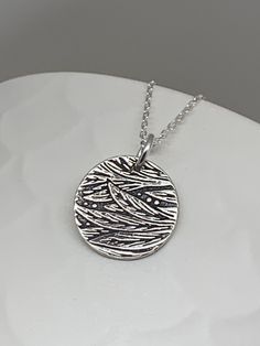 This beautiful floral circle silver necklace pendant has been entirely handmade using .999 fine silver. It has been cut from fine silver precious metal clay, textured, fired and oxidized. The pendant hangs from a sterling silver diamond cut cable chain. This unique and handmade necklace features an embossed floral leaf branch pattern. Pendant size: approximately 1/2 x 1/2 inches Chain length: adjustable at 16 and 18 inches can also be customized to whatever length needed The necklace is sent in Unique Etched Sterling Silver Necklace, Unique Silver Etched Necklaces, Etched Sterling Silver Necklaces, Silver Etched Sterling Silver Necklace, Artisan Silver Etched Necklace, Antique Silver Etched Sterling Silver Necklace, Silver Etched Nature-inspired Necklaces, Sterling Silver Etched Necklace For Gift, Etched Sterling Silver Pendant Necklace