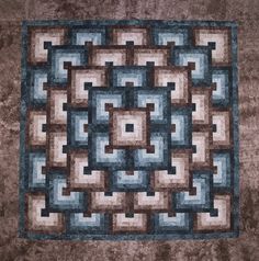 a brown and blue quilt with squares on it's sides, in the center