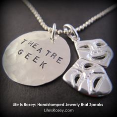 two silver pendants with the words theatre geekk and masks hanging from each other