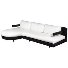 a black and white couch with two pillows on top of it's back end