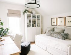 a living room filled with furniture and a white couch in front of a large window