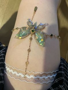 a close up of a person's leg with a dragonfly bracelet on it