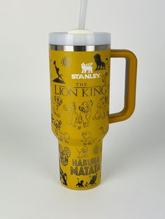 the lion king travel mug is yellow and has a straw in it's mouth