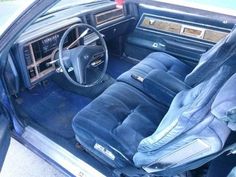 the interior of an old car with blue leather seats