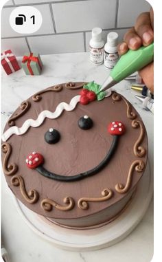 a person is decorating a chocolate cake with icing and decorations on the top