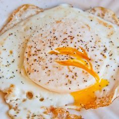 an egg is being fried on top of some kind of bread with mustard drizzled over it