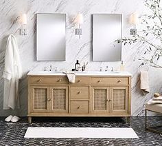 a bathroom with two sinks and mirrors on the wall