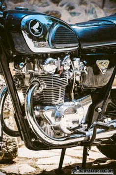 the front end of a black motorcycle parked next to rocks