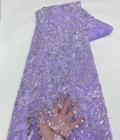 a person's hand on top of a purple dress