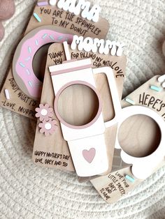 some wooden magnets are sitting on top of a plate with pink and white decorations