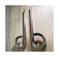 two metal handles on a wooden surface