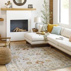 a living room filled with furniture and a fire place next to a mirror on the wall