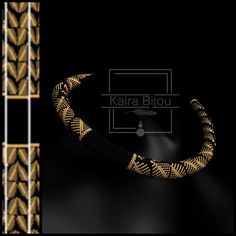 an image of a gold necklace with black and white designs on it, against a black background