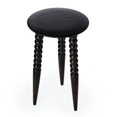 a small wooden stool with three legs and a black seat on the bottom, in front of a white background