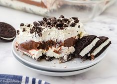 a piece of ice cream cake on a plate with oreo cookies next to it