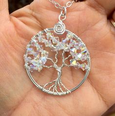 This beautiful Mini/Petite/Small sparkling Tree of Life Pendant is hand wire wrapped with Brilliant Swarovski Clear AB Crystals using .925 Sterling Silver wires for the tree trunk an branches.  It is a beautiful gift to give or receive! ~~The pendant measures about between 1.30  to 1.35 inch in diameter. The US quarter coin is about 1 inch(25mm) in diameter.  ~~The pendant  comes on  a .925 Sterling Silver cable chain & finished with a .925 sterling silver lobster clasp. ~~  Each pendant is handmade, so please allow slight variations from the shape of the branches and placement of the stones as shown The Tree of Life is a universal symbol found in many spiritual traditions around the world. The tree of knowledge, connecting to heaven and the underworld, and the tree of life, connecting all Wire Wrapped Silver Crystal Jewelry, Silver Wire-wrapped Crystal Jewelry, Silver Wire Wrapped Crystal Jewelry, Adjustable Wire Wrapped Crystal Necklaces, Adjustable Crystal Necklace With Wire Wrapped Detail, Adjustable Wire Wrapped Crystal Jewelry, Handmade Crystal Jewelry For Anniversary, Sparkling Crystal Necklace For Gifts, Silver Wire Wrapped Round Crystal Necklace