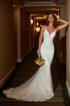 a woman in a wedding dress is standing on the stairs