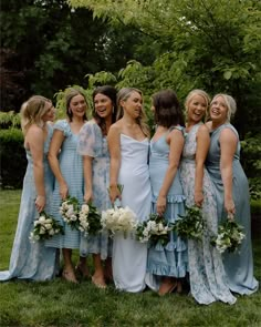 a group of women standing next to each other on top of a lush green field