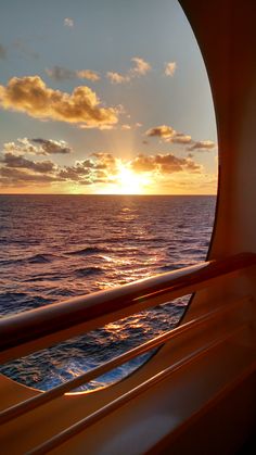 the sun is setting over the ocean as seen from a boat's deck in the water