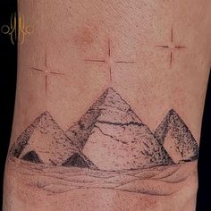 a tattoo with three pyramids on it