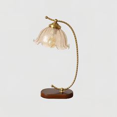 a lamp that is on top of a wooden base and has a light bulb attached to it