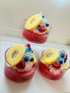 three glasses filled with fruit and ice cream on top of a white counter next to each other