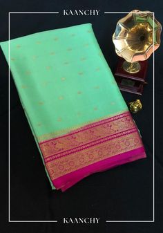 Indulge in the captivating allure of this rare Green and Pink Mysore Silk Saree, where elegance meets sophistication. Adorned with intricate golden motifs, this saree boasts of a rich texture and a subtle sheen that will leave you spellbound. With its lightweight fabric and graceful drape, this saree is perfect for any special occasion or formal event. The vivid green hue adds a touch of vibrancy, making it a true masterpiece in your wardrobe. Feel the luxurious comfort and exude effortless grace with this timeless beauty.  An unstitched blouse fabric is included. SILK MARK CERTIFIED | 120 GSM Please note that as a handmade item, there may be slight variations in weaving, which are typical of the artisanal process and not considered defects. *NOTE: There might be slight differences in the Formal Gold Banarasi Silk Traditional Wear, Formal Pista Green Traditional Wear For Diwali, Green Formal Traditional Wear For Festivals, Gold Saree With Zari Work For Formal Occasions, Elegant Traditional Wear In Pista Green With Self Design, Elegant Pista Green Traditional Wear With Self Design, Elegant Meenakari Saree For Ceremonial Occasions, Classic Diwali Traditional Wear With Zari Work, Elegant Gold Traditional Wear With Traditional Patterns