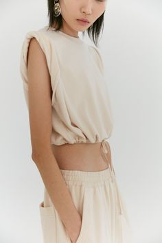 This slightly cropped sleeveless top features a boxy silhouette and a rolled shoulder detail. Trimmed with a tencel drawstring, this top can be worn relaxed or synched at the waist to create a shorter blouson shape. Made in our terry looped cotton jersey and finished with a ribbed crew neck, the front is discreetly branded with our tonal monogram embroidery. PRODUCT CODE: ROLLEDSLEEVETOP01/TJ01.002 Begin Accordion Snippet .so-tab {position: relative;width: 100%;overflow: hidden;margin: 0px 0;}.s Neutral Loungewear, Cropped Sleeveless Top, Embroidery Product, Monogram Embroidery, Jersey Top, Double Face, Dream Clothes, Crop Shirt, Fashion Essentials