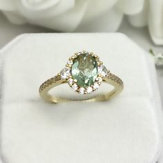 This beautiful ring is made from genuine 925 sterling silver with yellow gold plating. Ring details- -The Main stone is an oval cut 8mm by 6mm Natural Green Amethyst Stone -Side stones are round 3mm and 1mm Round clear simulated diamonds -Ring is casted in solid 925 sterling silver with yellow gold plating (rose gold and white rhodium plated also available, please check the drop down menu for more options) -The Total face height of the ring measures 10mms and the band width measures 1.5mms -Each Gold Amethyst Ring With Center Stone For Wedding, Gold Amethyst Ring For Wedding, Fine Jewelry, Heirloom Gold Emerald Ring With Halo Detail, Heirloom Gold Emerald Ring With Halo, Elegant Gold Amethyst Ring With Halo Setting, Yellow Gold Amethyst Ring With Center Stone For Wedding, Oval Yellow Gold Emerald Ring With Halo, Elegant Green Oval Amethyst Ring, Gold Emerald Ring With Halo