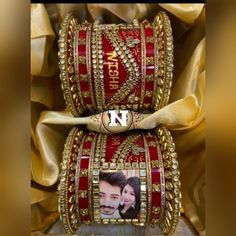 two bangles with pictures on them are sitting next to each other in gold and red