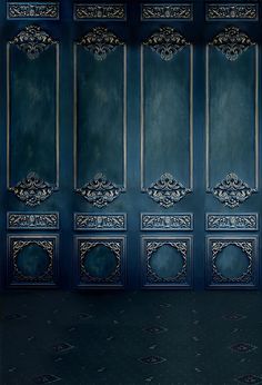 an empty room with blue walls and ornate designs on the doors, in front of a black floor