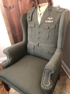 an army uniform sitting on top of a chair in front of a wooden wall and door