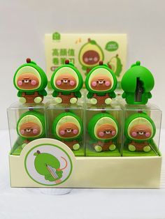 a display case filled with little green toy figures on top of a white tablecloth