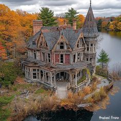 an old abandoned house sitting in the middle of a lake surrounded by autumn trees and foliage