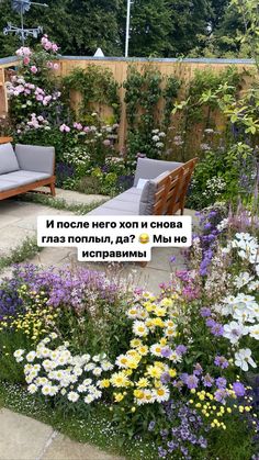 an outdoor seating area with flowers in the foreground and a wooden bench on the other side