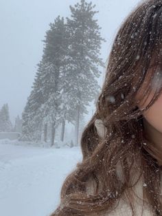 a woman with long hair standing in the snow