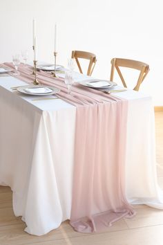 the table is set with plates, silverware and pink linens for an elegant look