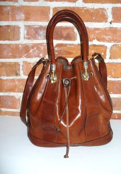 Wonderful whiskey brown m Valentina feed bag. Great condition with average signs of  use. No significant issues to mention other than the lining looks a little tired. There are also some missing stitches on the shoulder strap. Made in Italy.  It has one interior zipper  pocket.  Measures 11" X11" x 6"" with a 7" handle drop and 16" shoulder strap drop Please measure carefully and feel free to ask more questions regarding size and condition as there are no refunds or exchanges. Lot Classic Brown Bucket Bag With Double Handle, Classic Formal Brown Bucket Bag, Formal Brown Hobo Bag With Leather Handles, Brown Formal Hobo Shoulder Bag, Formal Brown Hobo Shoulder Bag, Vintage Satchel Hobo Bag For Errands, Vintage Hobo Bag With Adjustable Strap For Errands, Vintage Brown Tote Bucket Bag, Classic Brown Bucket Bag