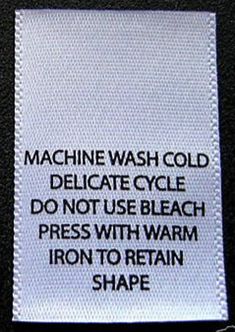 a white label that says machine wash cold delicate cycle do not use bleach press with warm iron to retain shape