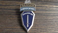 an air force badge is hanging on a wooden table with the words ranger airborne below it