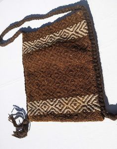 Lovely vintage brown and light beige woven, chunky wool, hippy style bag, circa 1970's-80's.  With plaited dark brown woollen strap and knotted tassels on each side, it has an attractive diamond motif design and is quite strong and sturdy. The plaited strap runs down each side to finish with the knotted tassel.  There is no fastener but a prestud could be affixed, if desired,  inside or a a button/toggle on the outside with a loop  sewn on the other side and looping over the top.  The strap is f Artisan Brown Shoulder Bag With Braided Handles, Brown Crochet Bag With Tassels For Everyday Use, Bohemian Brown Woven Shoulder Bag, Everyday Brown Crochet Bag With Tassels, Vintage Handwoven Beige Bag, Brown Rectangular Crochet Bag With Fringe, Vintage Beige Handwoven Bags, Artisan Brown Fringe Bag, Brown Artisan Bags With Fringe