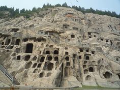 a large rock formation with many holes in it's sides and steps leading up to the top